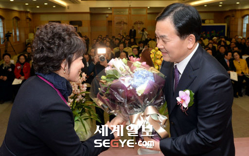 20日、ソウル龍山区の世界平和統一家庭連合の大講堂で開かれた韓国宗教協議会の会長が·就任式のイベントで、第20代会長を務める世界平和家庭連合ユギョンソク会長(右)が妊婦姫韓国の宗教の女性協議会副会長からのお祝いの花束を受けてている。 ギムボムジュン記者