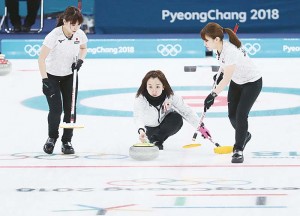 平昌冬季五輪のカーリング女子３位決定戦・英国戦第１エンドで、ストーンを投じる藤沢五月選手（中央）。韓国の人気女優に似ているなどと韓国でも関心を集めた＝２月２４日、韓国・江陵