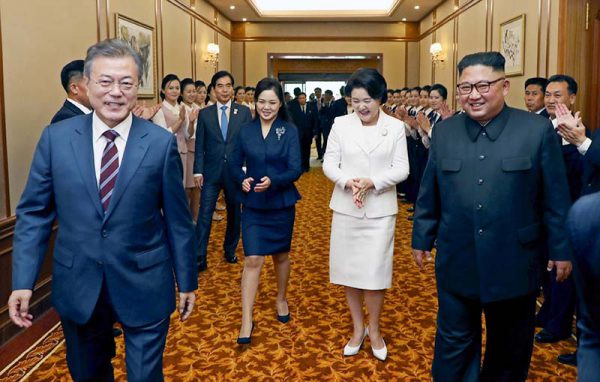 １８日、平壌の百花園迎賓館に到着し、談笑しながら歩く韓国の文在寅大統領（左）と北朝鮮の金正恩朝鮮労働党委員長（右）（ＥＰＡ時事）